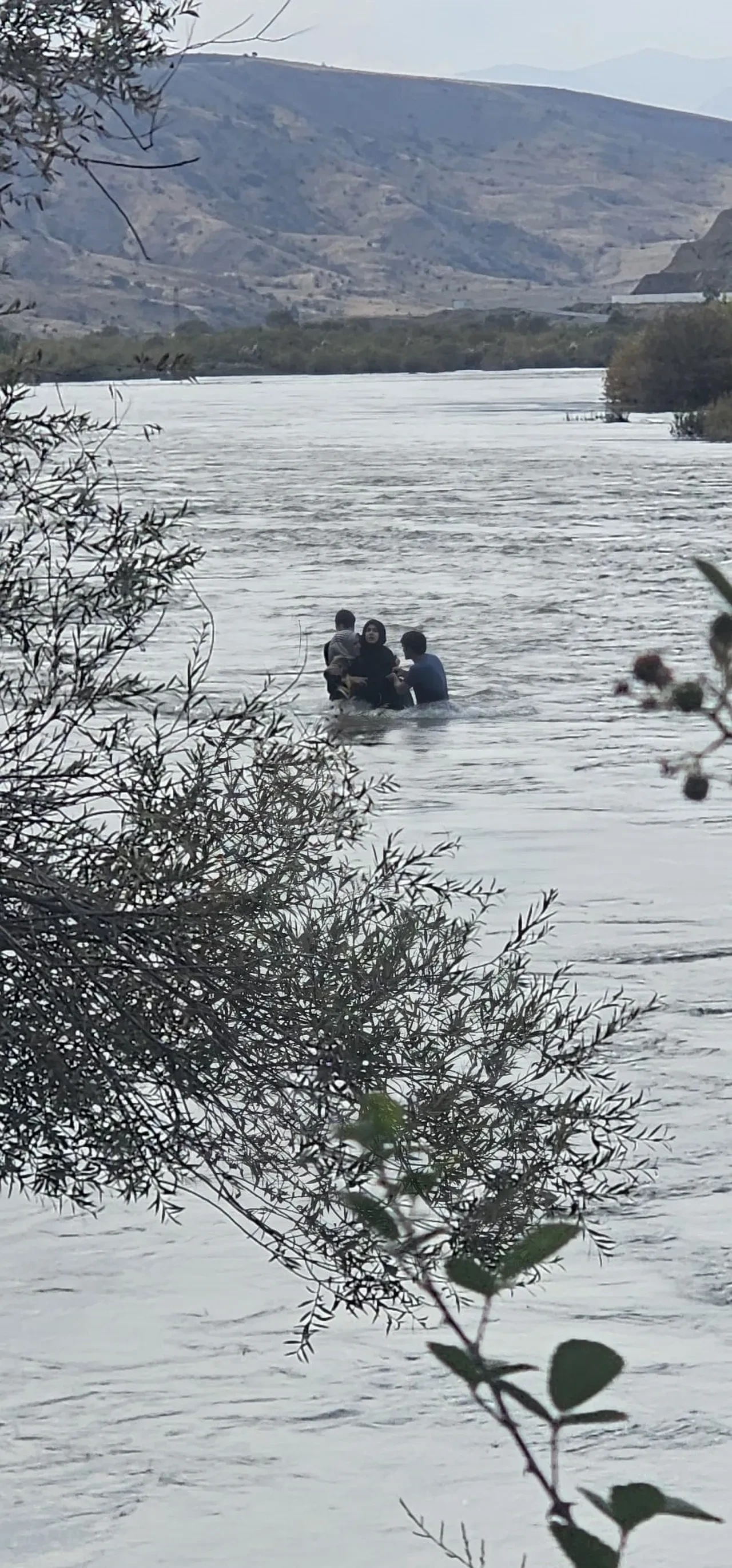 Korku dolu anlar: Bir aile nehir ortasında kurtulmak için birbirine sarıldı