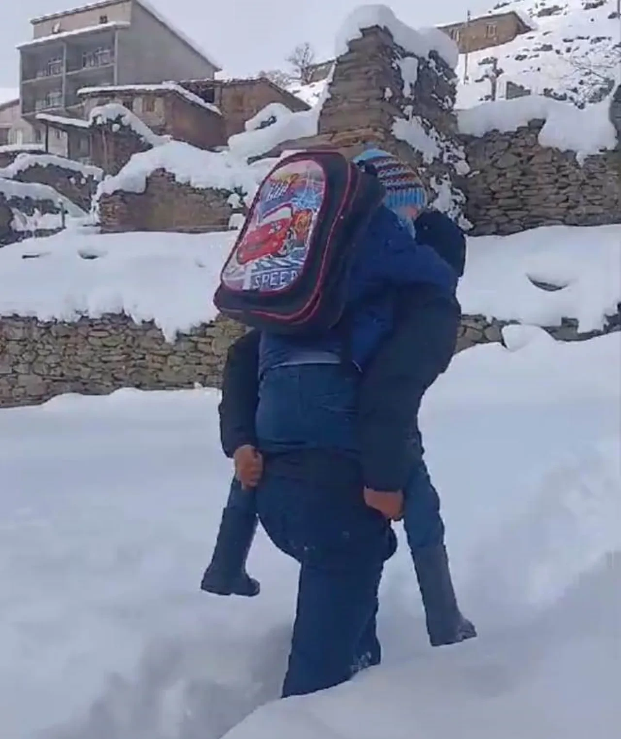 Kardan yürüyemeyen öğrencisini sırtında taşıdı