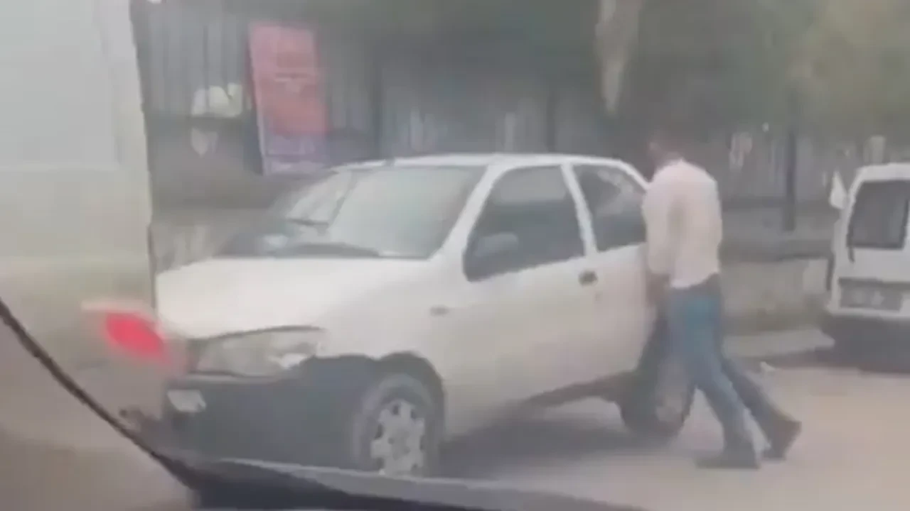 İzmir'de şoke eden anlar! Yolu daraltan otomobilleri elleriyle kaldırıp kenara itti