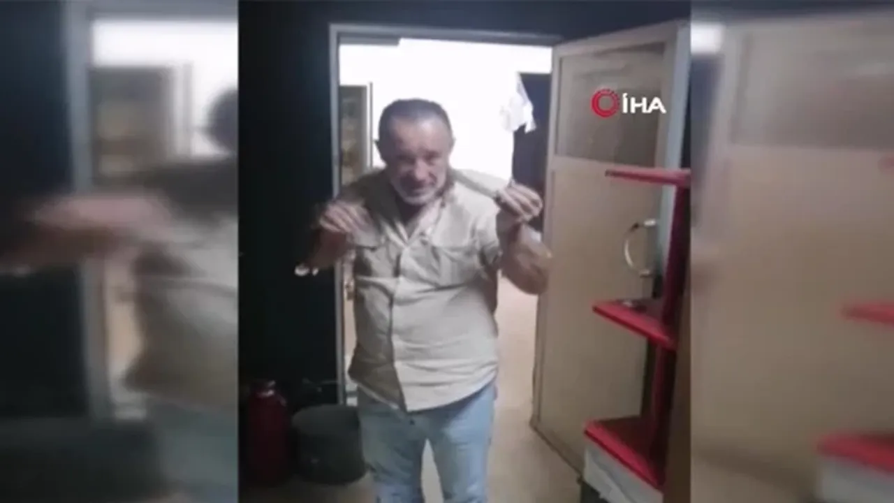 İş yerine giren 2 metrelik yılanı eline alıp boynuna doladı