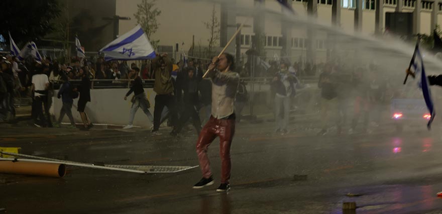 <p>İsrail Kamu Yayın Kuruluşuna (KAN) göre İsrail polisi Tel Aviv merkezindeki Ayalon Caddesi'ni demir bariyerlerle kapatmaya çalışan ve ateş yakan göstericilere müdahale etti.</p>