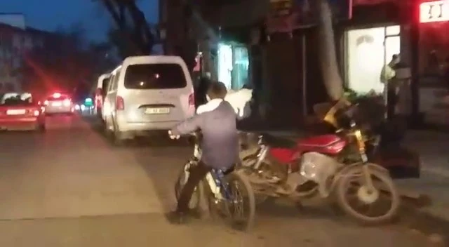 Bir eliyle kedisini tuttu, diğer eliyle bisikleti sürdü