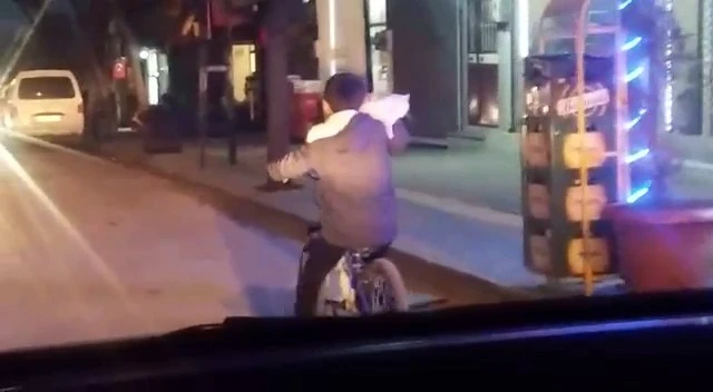 Bir eliyle kedisini tuttu, diğer eliyle bisikleti sürdü