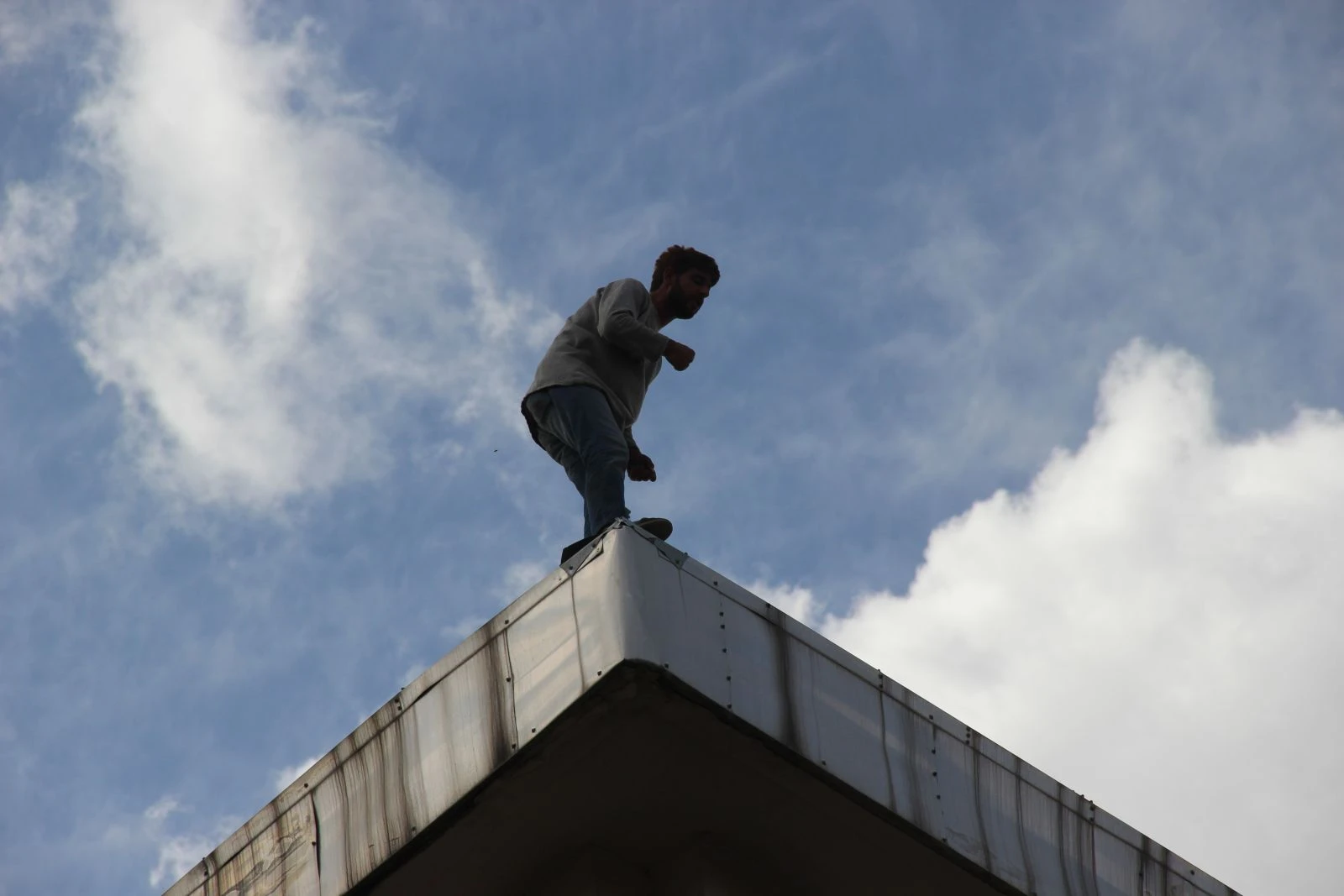 Banka çatısındaki şahsı görenler, Covid-19'u unuttu