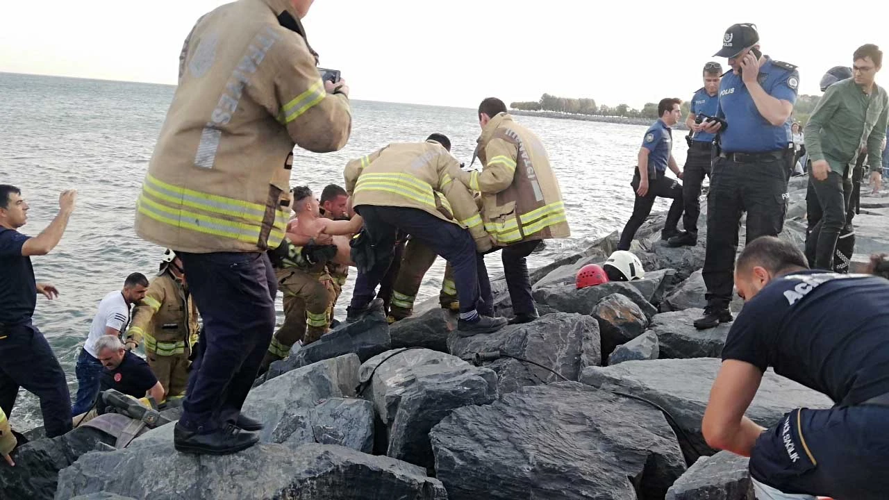 Denize düşen genç kayalıklara sıkıştı