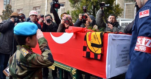 Asker kıyafetli küçük çocuk şehidin tabutuna gül bıraktı