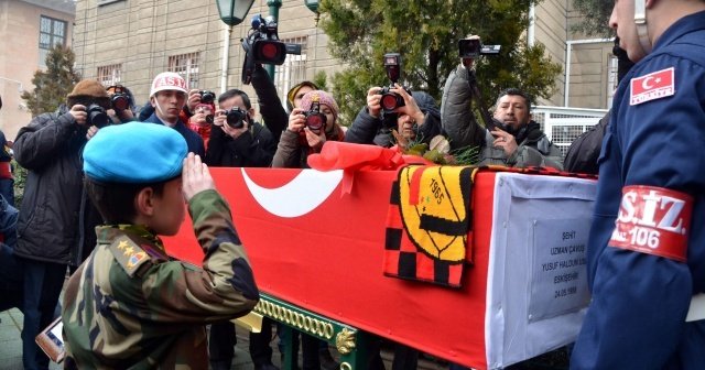 Asker kıyafetli küçük çocuk şehidin tabutuna gül bıraktı