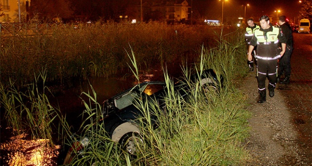 Alkollü sürücü kanala devrilen otomobilinde sigara içmeye devam etti