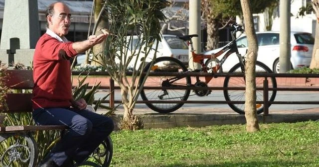 Serçelere ıslık çalıp elleriyle besliyor