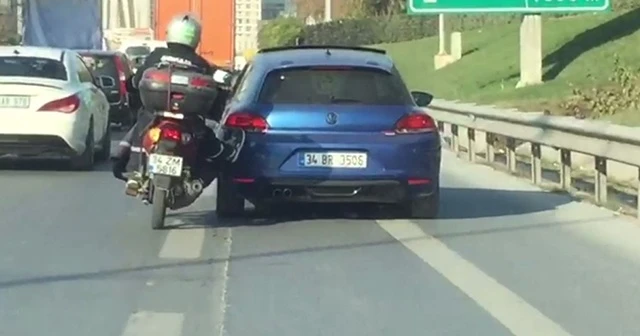 Motosiklet sürücüsü yolda kalan aracı ayaklarıyla itti