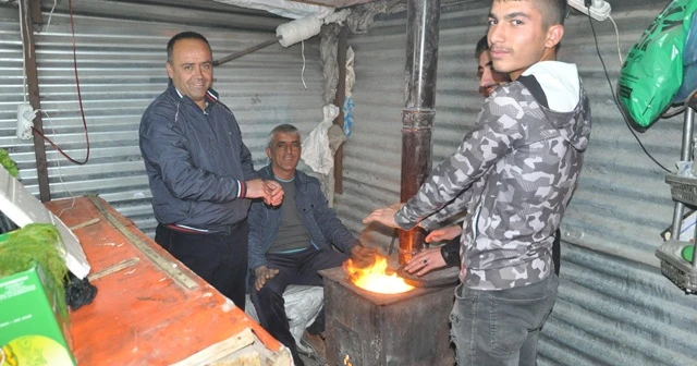 Soğuk havaya karşı soba yakarak müşteri bekliyorlar