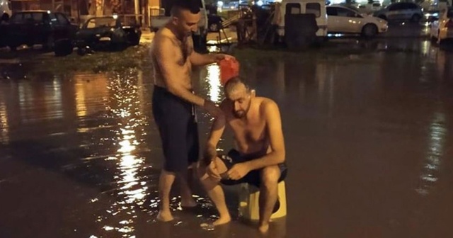 İzmir&#039;de su kesintisine dikkati çekmek için yağmur suyuyla sokakta yıkandılar