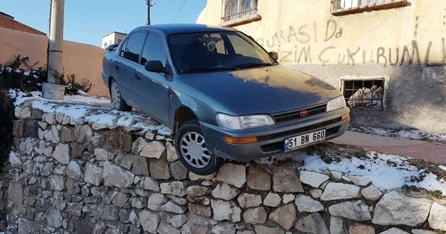 Buzlanmadan dolayı kayan otomobil duvar üzerinde asılı kaldı