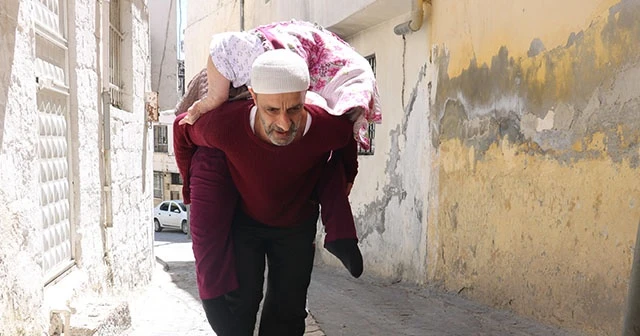 Yatalak annesini sırtında gezdirdi
