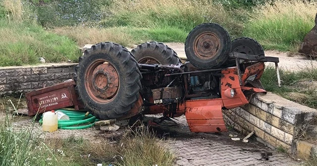 Devrilen traktörde az daha canından oluyordu