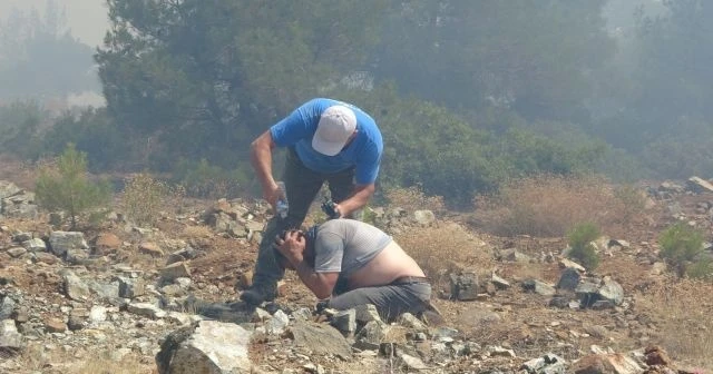 Dumandan etkilenen görevli canı pahasına alevlerle mücadele ediyor