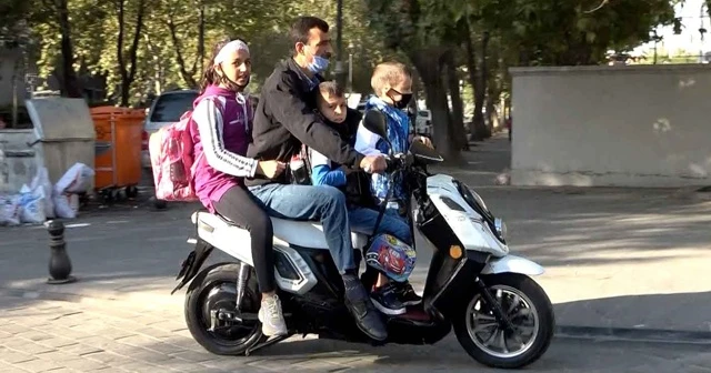 Bir motosiklette bir veli 3 öğrenci