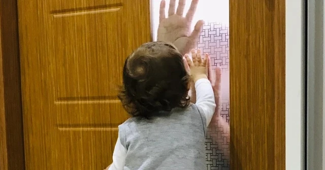 Koronalı baba çocuğunu camın arkasından seviyor