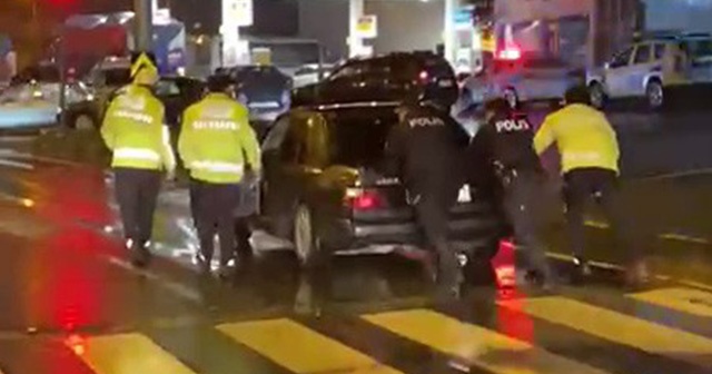 Trafik polisi yolda kalan otomobili iterek, sürücüye yardım etti