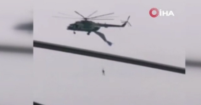 Askeri helikoptere takılan paraşütçü havada asılı kaldı