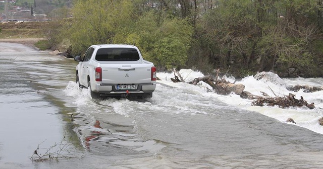 Su altında kalan köprüden tehlikeli geçiş