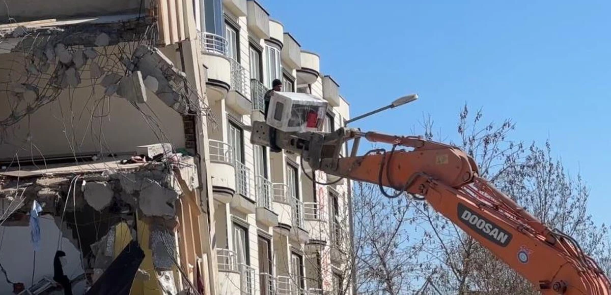 Hasarlı binadan ekskavatör ile eşya indiren depremzede yürekleri ağza getirdi