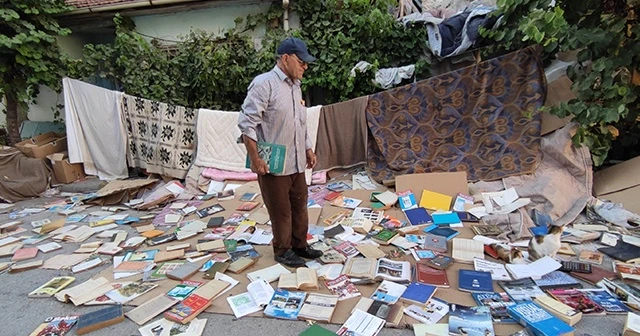 Yüzlerce kitabı sokakta böyle kuruttu