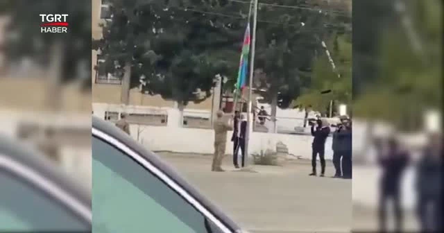 Aliyev, Azerbaycan bayrağını öperek göndere çekti