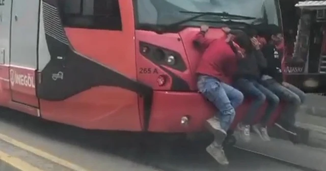 Bursa'da tramvay arkasında tehlikeli yolculuk