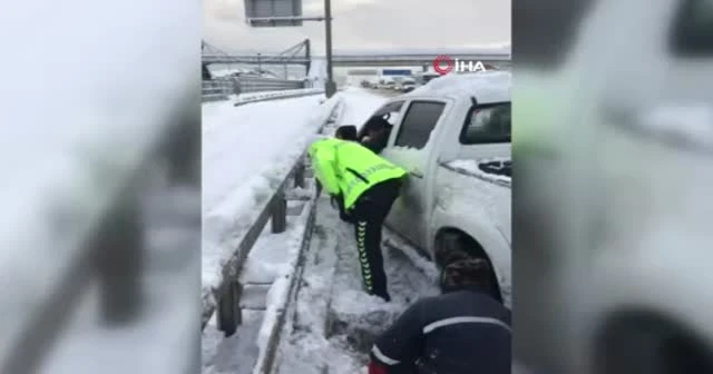 Polisler elleriyle kar küreyerek yolda kalan sürücülere yardım etti