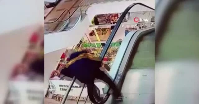 Yürüyen merdivenin bandına takıldı, aşağıya düştü