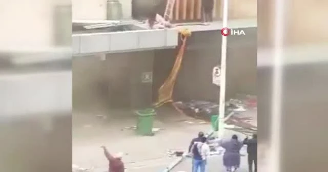 Yağmacılar ateşe verdi anne binadan bebeğini atarak kurtardı