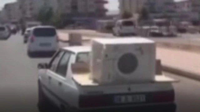 Otomobil üstünde çamaşır makinesi taşıdı