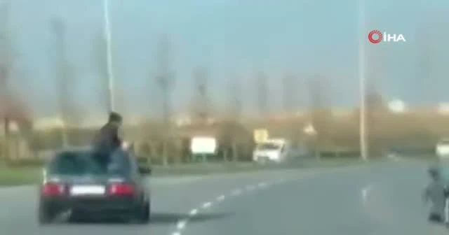 Video çekmek için arabadan sarktı