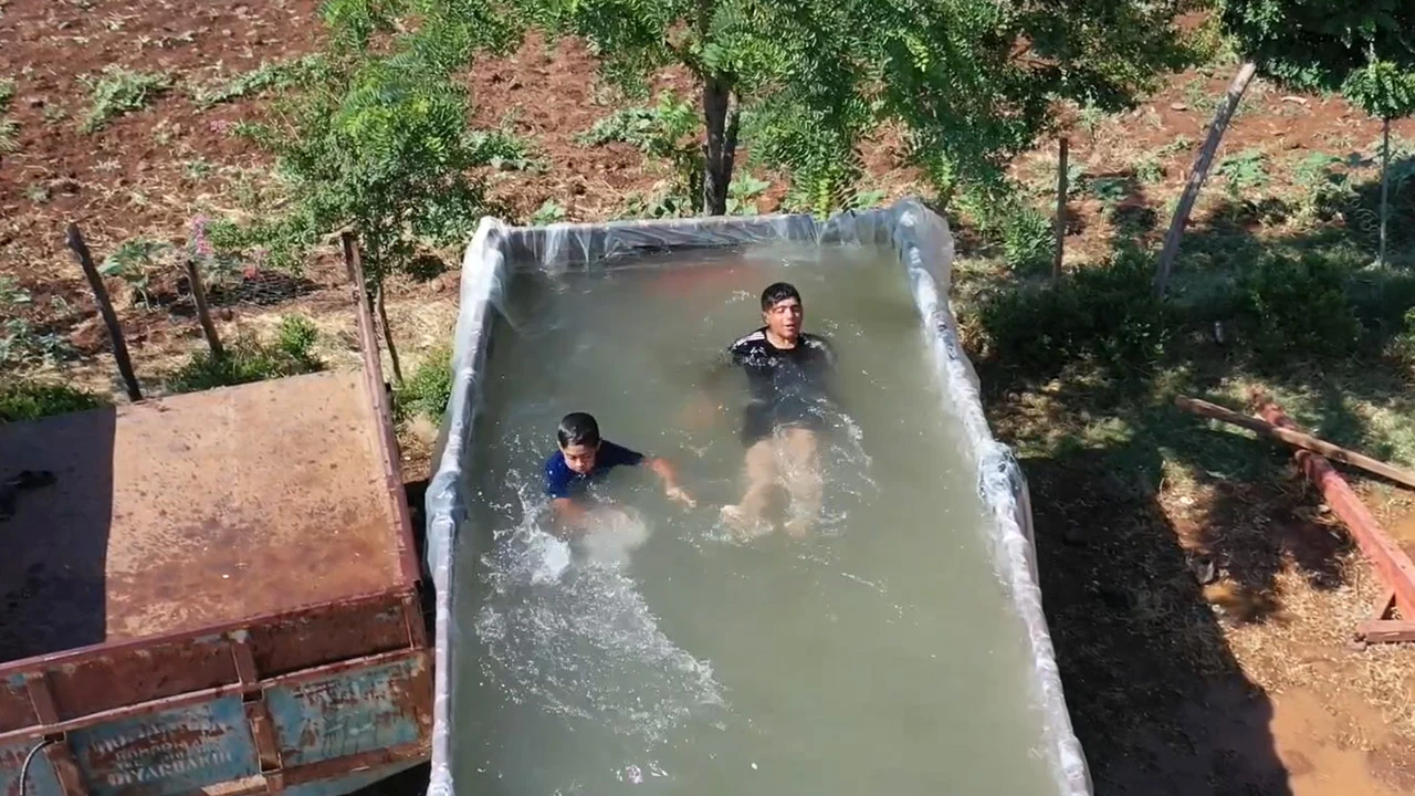 Sıcaktan bunalan çocukları için römorktan havuz yaptı!