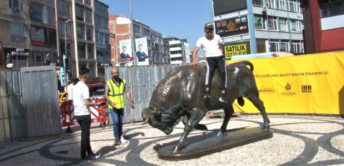 Bakıma alınan Boğa Heykeli’nin üzerine çıkıp fotoğraf çektirdi